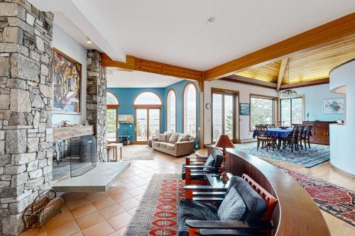 a living room with a large stone fireplace at Oceanfront Gem in East Boothbay