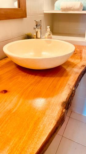 a white sink on a wooden counter in a bathroom at Résidence Cocody in Sainte-Anne