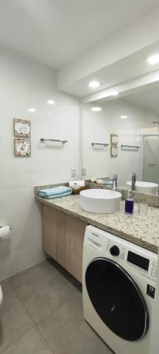 a bathroom with a sink and a washing machine at Búzios Beach Resort Residencial 1322 in Búzios