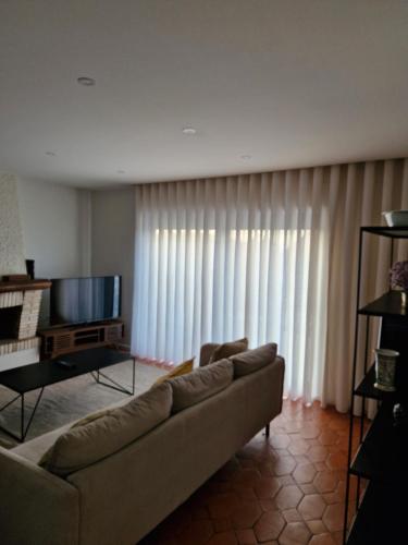 a living room with a couch and a television at Casa Francisca praia de Mindelo in Mindelo