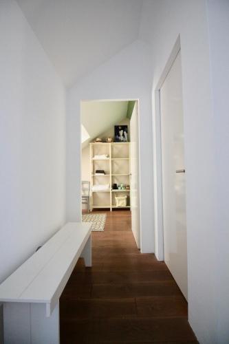 a hallway with a white bench in a room at Private room in Design House near Amsterdam in Halfweg