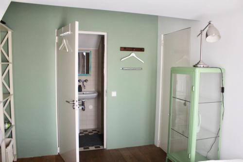 a bathroom with a toilet and a sink and a door at Private room in Design House near Amsterdam in Halfweg