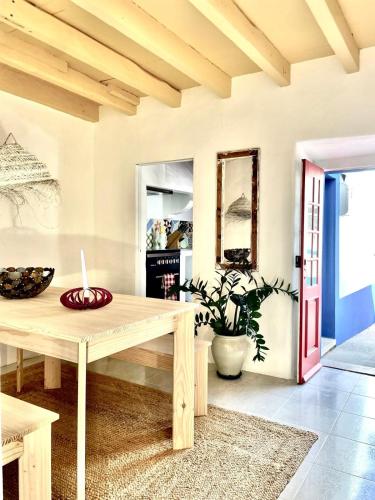 a living room with a wooden table and a red door at Boutique Surf House in Surf Paradise in Santo Isidoro