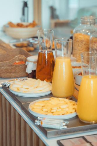 a buffet with plates and glasses of orange juice at La Maison Gaïa Hôtel & Spa in Torreilles