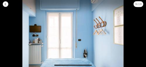 Habitación azul con cama y puerta en Sea Watch Blue Apt, en Borghetto Santo Spirito