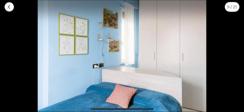 1 dormitorio con cama azul y almohada rosa en Sea Watch Blue Apt, en Borghetto Santo Spirito