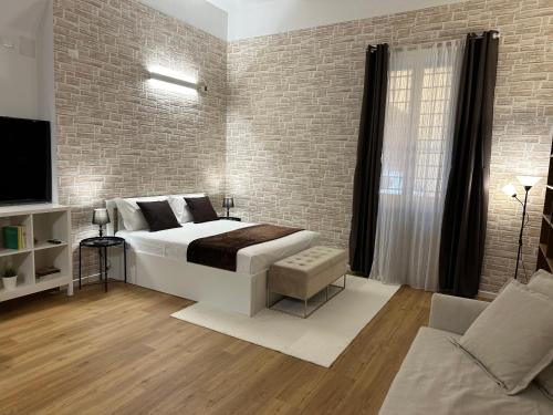 a bedroom with a bed and a brick wall at No Name Prestige Apartment in Bologna