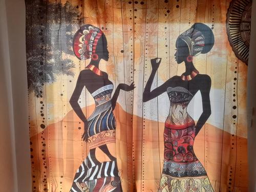 three women in dresses are on a curtain at Appartement familial spacieux avec climatisation in Ziguinchor