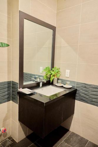a bathroom with a sink and a mirror at Charm Champion Villa Hoian in Hoi An