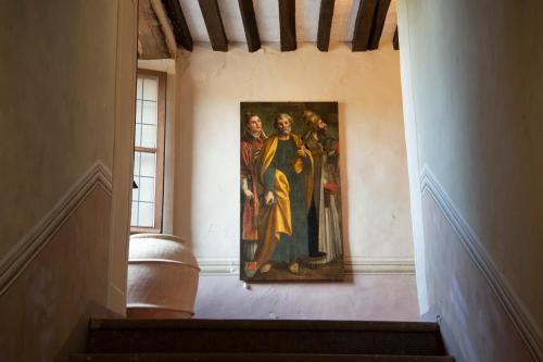 a painting hanging on a wall in a hallway at Il Castello di San Michele in San Michele in Teverina