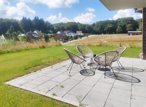 a group of chairs sitting on a patio at INIKAMA - Elegantes Apartment in Rosengarten