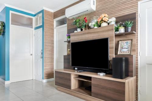 a living room with a flat screen tv on a wooden wall at leroy place in Kingston