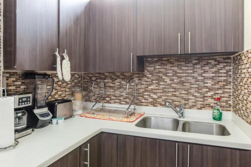 a kitchen with a sink and a microwave at leroy place in Kingston