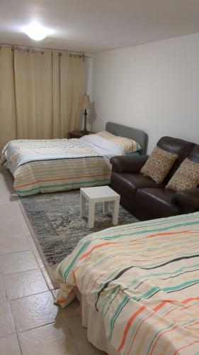 a living room with two beds and a couch at Whole House Fair Price Great Amenities in Richmond Hill