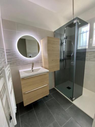 une salle de bain avec un lavabo et une douche dans l'établissement Maison familiale dans le Médoc, à Le Pian-Médoc