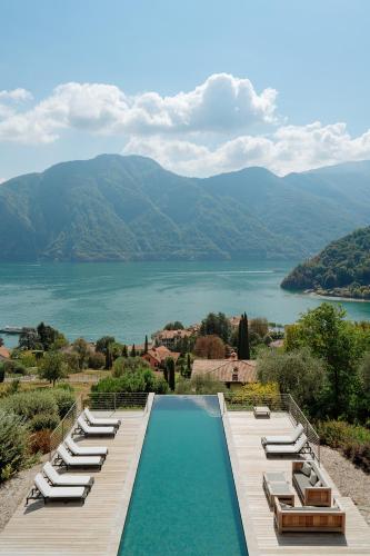 a pool with lounge chairs and a view of a lake at Villa MUSA in Lenno