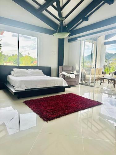 1 dormitorio con cama y alfombra roja en Lujosa casa cerca al aeropuerto, en Medellín