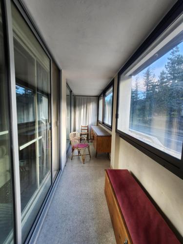 Cette chambre dispose de fenêtres, d'un banc et d'un bureau. dans l'établissement Appartement 5mn des pistes, à La Salle Les Alpes