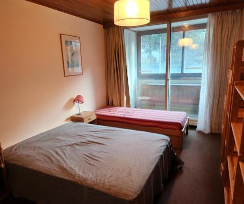 une chambre d'hôtel avec deux lits et une fenêtre dans l'établissement Appartement 5mn des pistes, à La Salle Les Alpes