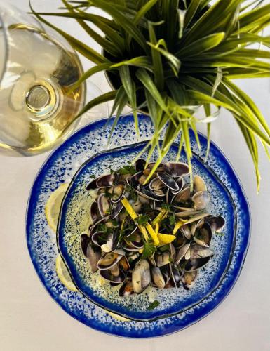 a blue plate with mussels and a plant on a table at Hotel El Siglo in Valencia