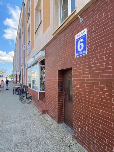 a red brick building with a parking sign on it at Apartament przy ratuszu in Koszalin