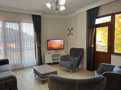 a living room with two chairs and a television at Rize Akarsu Apart in Rize