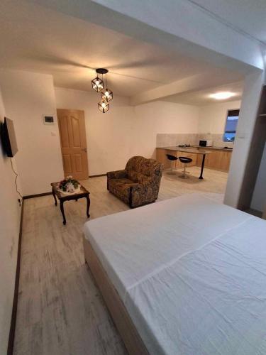 a bedroom with a bed and a chair and a living room at Ant's residence in Curepipe