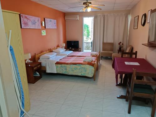 a hotel room with a bed and a table at Rantzo Holiday Apartments in Pissouri