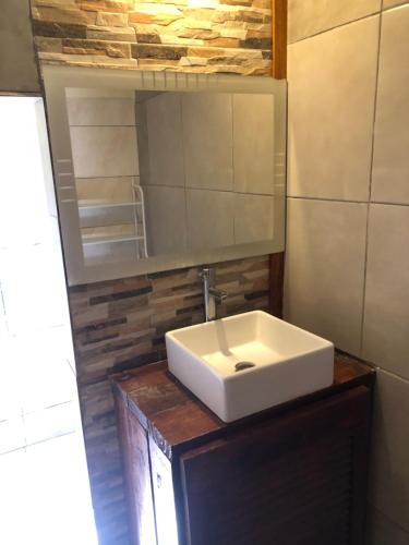 a bathroom with a white sink and a mirror at Casa la Popa in Barra de Valizas