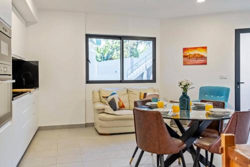 a kitchen and living room with a table and chairs at Tornos in Funchal