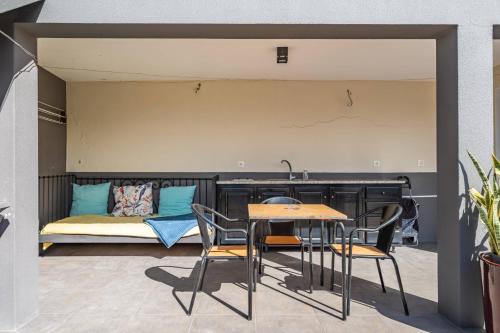 a patio with a table and chairs and a bed at Tornos in Funchal