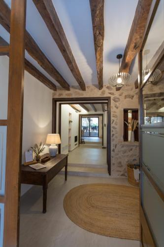 a living room with wooden ceilings and a table at Stadthaus - Alica 8 - Pool, Barbecue, Garten, Terrassen und im Winter Zentralheizung und Kamin, hochwertig saniert in Pollença