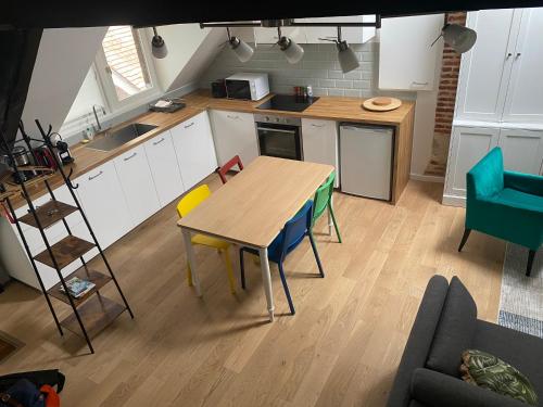 une cuisine avec une table et des chaises en bois dans l'établissement LE PAPILLON BLEU, à Honfleur