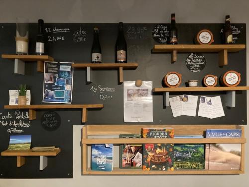 a wall with shelves and wine bottles on it at Hôtel Des Argousiers in Ambleteuse