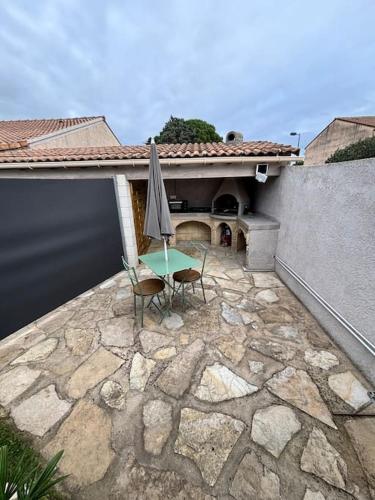 une terrasse avec une table et un parasol dans l'établissement La cabane de Lili, à Lapalud