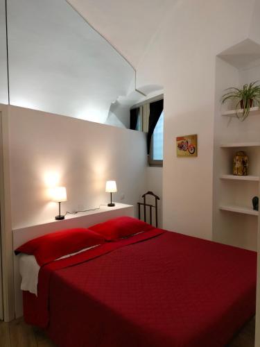 a bedroom with a red bed with two lamps at Casa 57 in Lovere