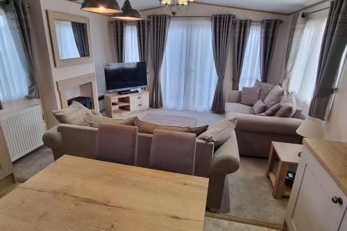 a living room with a couch and a tv at Ramblers Retreat in Cockermouth