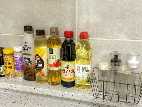 a shelf with bottles of oils and a basket at Casa Choi 3 Bedroom Apartment in Seoul in Seoul
