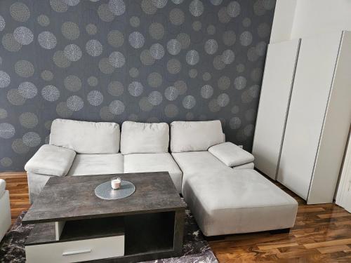 ein Wohnzimmer mit einem weißen Sofa und einem Couchtisch in der Unterkunft Gold Appartman in Wien