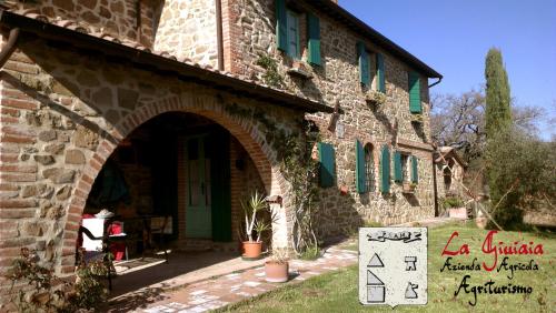 a stone building with a sign in front of it at La Giuiaia - Agriturismo Azienda Agricola in Ravigliano