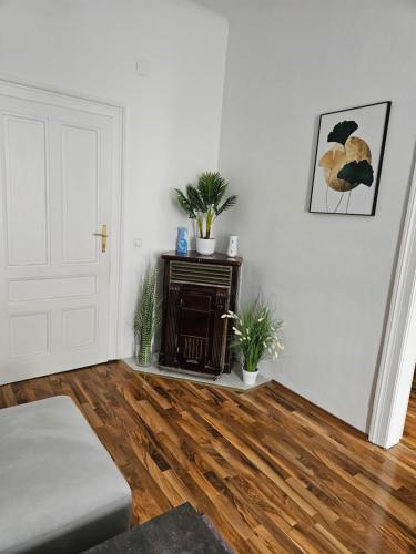 ein Wohnzimmer mit weißen Wänden und Holzböden in der Unterkunft Gold Appartman in Wien