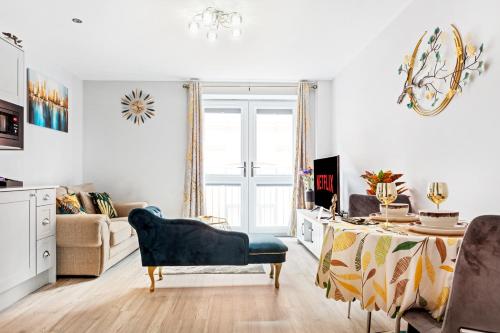 a living room with a blue chair and a table at Luxurious Flat at Leicester Town in Leicester