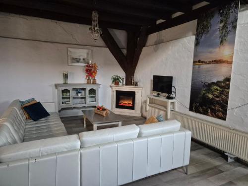 a living room with a white couch and a fireplace at Noord-Hollands Hof Dream in Spijkerboor