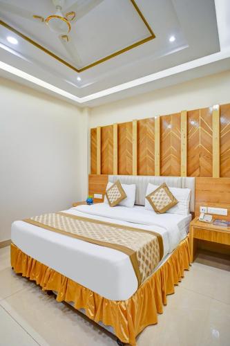 a bedroom with a large bed with a wooden headboard at Hotel Gold Palace - 03 Mins Walk From New Delhi Railway Station in New Delhi