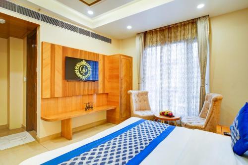 a bedroom with a bed and a desk and a window at Hotel Gold Palace - 03 Mins Walk From New Delhi Railway Station in New Delhi