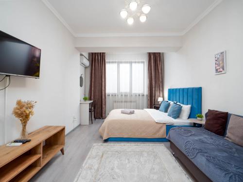 a hotel room with a bed and a couch at Appartments " Zhetysu-4" in Almaty