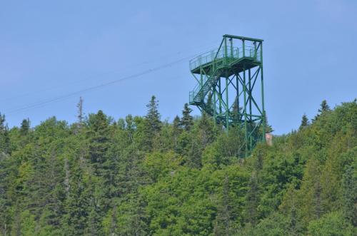 a tower on top of a hill with trees at Gite Nycole in Perce
