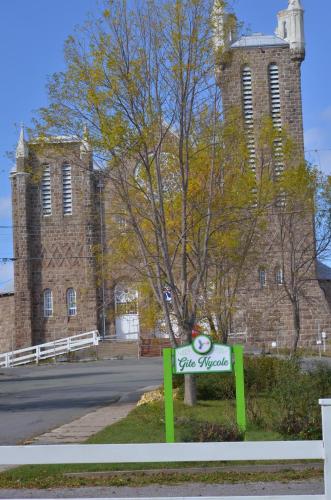 a sign in front of a building with a tower at Gite Nycole in Perce