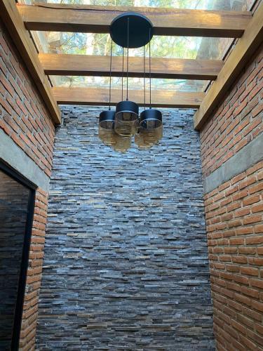 aendant light hanging from a brick wall with a wooden ceiling at Cabaña El Atardecer, Mazamitla in Mazamitla