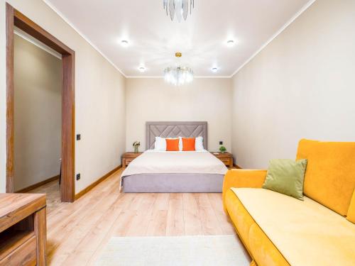 a bedroom with a bed and a couch at Apartments on Baitursynova 2 in Almaty